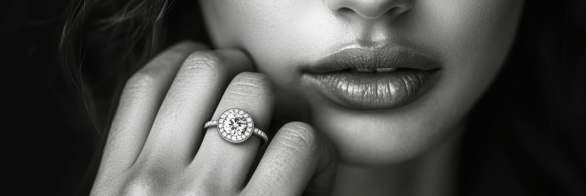 Close-up of a woman's face wearing a diamond ring on a dark background