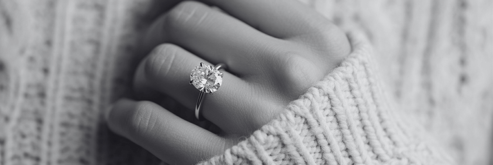 Close-up of a hand wearing a diamond ring with a blurred background
