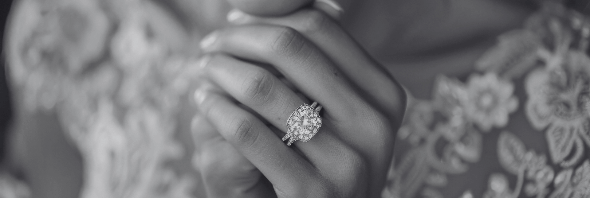 Close-up of a hand wearing a diamond ring with a blurred background