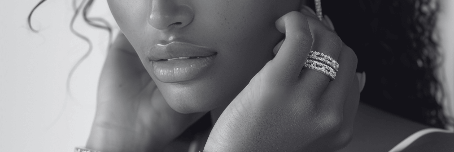 Close-up of a woman wearing diamond earrings and a ring, with a blurred background.